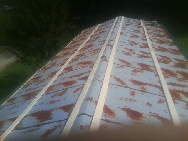 Rusted metal roof panels with new wood purlins before replacement — Storm Damage Roof Repair in Louvale by Roofing Brothers