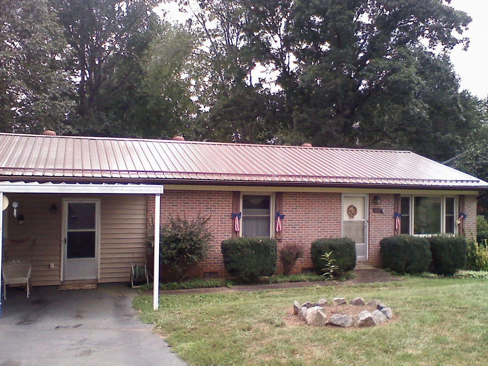 Bronze metal roof and carport on a brick ranch home — Roof Repair work by our crew in Louvale