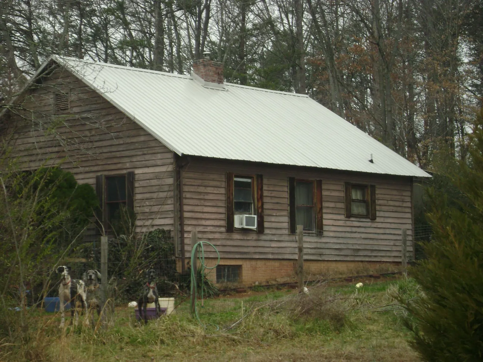 White metal roof on an old wood sided farmhouse, from a Metal Roof Installation job in Louvale